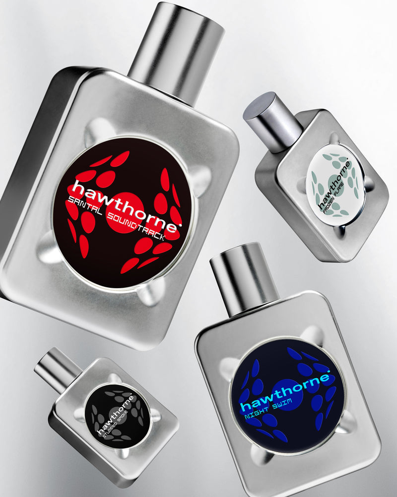 Four metallic perfume bottles are shown, each labeled “hawthorne” with different colored designs: red, blue, black, and gray, all with bold circular logos and metallic caps.